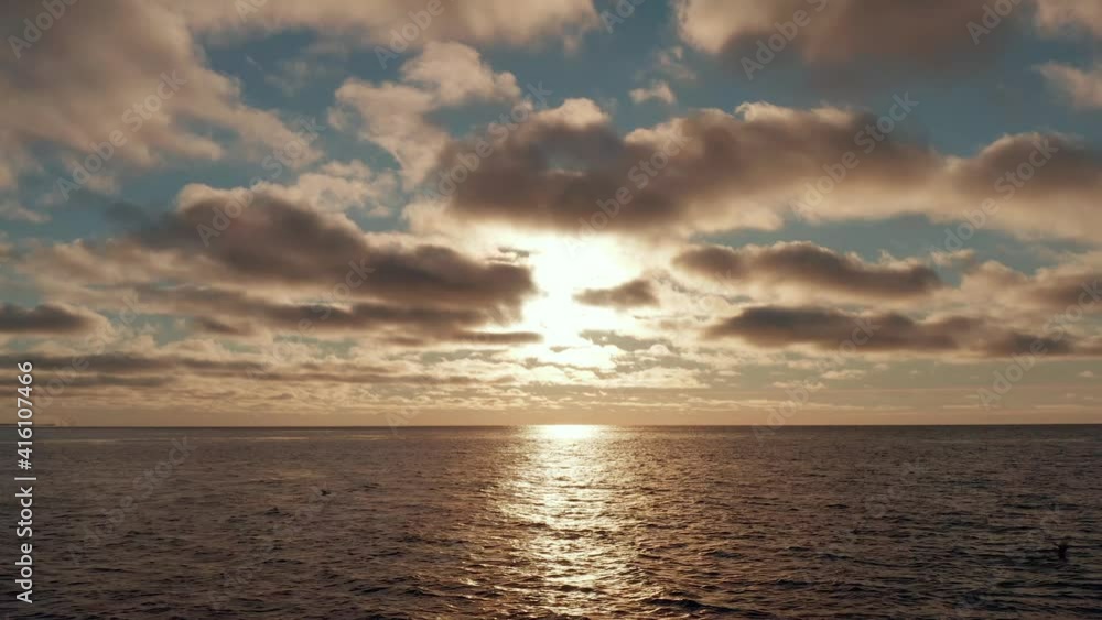 Epic aerial view of golden sunset, sunrise at sea with strong reflection. Calm smooth water, large gold pink clouds, bright orange sun light. Forward camera movement. 4k footage. Epic aerial view of golden sunset, sunrise at sea with strong reflection. Calm smooth water, large gold pink clouds, bright orange sun light. Forward camera movement. 4k footage.