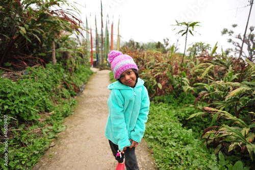 little girl walking in the garden on the hills with peace flags in the backdrop