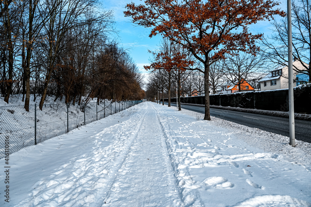 Footpath next to a road is covered with snow Footpath next to a road is covered with snow