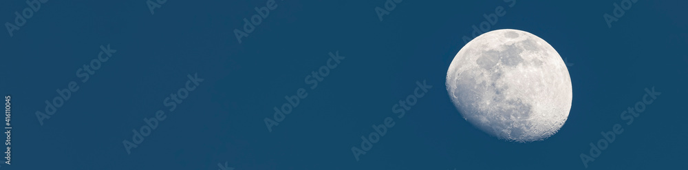 Stunning close up view of a crescent moon with detailed craters during daylight. Dark blue sky with copy space. Stunning close up view of a crescent moon with detailed craters during daylight. Dark blue sky with copy space.