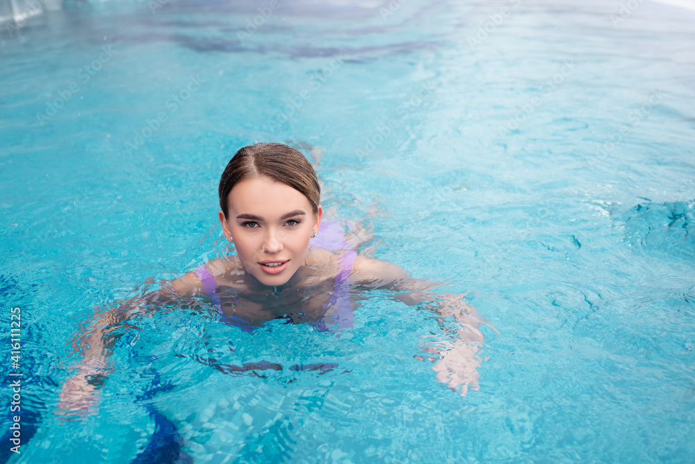 young woman swimming in water of hot spring pool