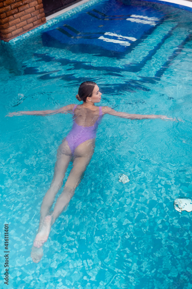 high angle view of young woman in swimsuit bathing in outdoor pool