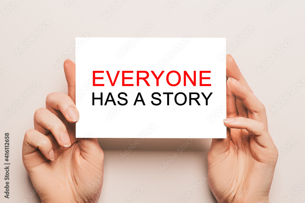 Female hands hold card paper with text Everyone has a story on a yellow background. Business and finance concept Female hands hold card paper with text Everyone has a story on a yellow background. Business and finance concept