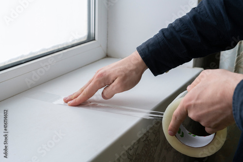 hands holding and a[[lying adhesive tape on the surface photo