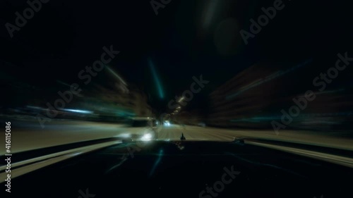 Fast drive through a winter city overtaking another car by viewing behind from the drivers cartop at a cold winter night. Snow lies on the street, cars getting blurry by the fast motion. photo