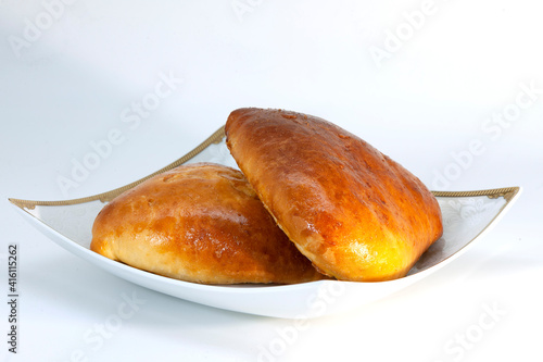 two baked kulebyaki with fish on a plate