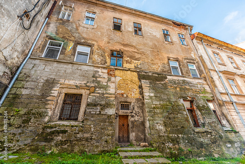Lviv Ukraine old run-down derelict apartment house with windows abandoned architecture in summer and peeling wall wide angle view exterior