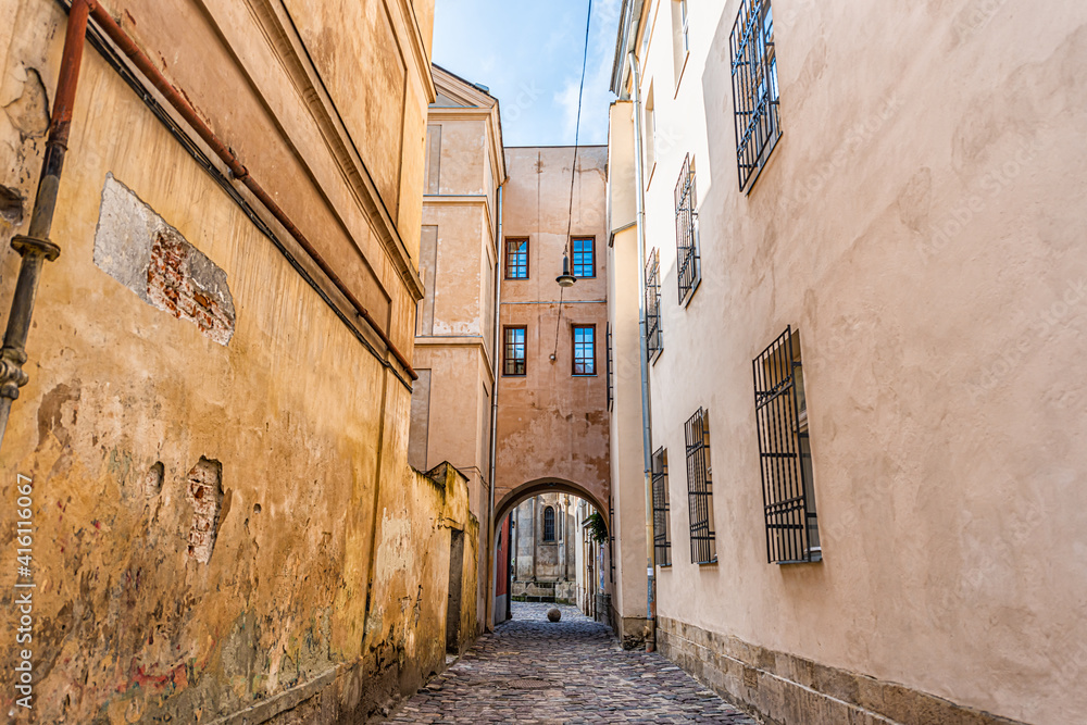Fototapeta premium Lviv, Ukraine colorful pastel building historical architecture in Ukrainian city with passage archway narrow alley street