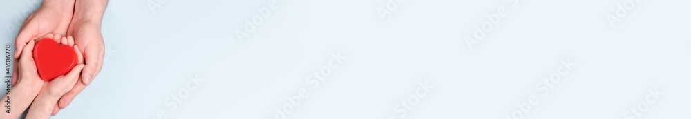 Man give red heart to kid as couple. Healthcare and hospital medical concept. Symbolic of Valentine day.Top view with space for text. Banner Man give red heart to kid as couple. Healthcare and hospital medical concept. Symbolic of Valentine day.Top view with space for text. Banner