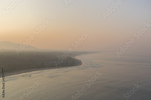 Aerial panoramic view of beautiful Murdeshwar beach on a foggy winter morning with orange and yellow shades in the sky at Murdeshwar  Karnataka  India