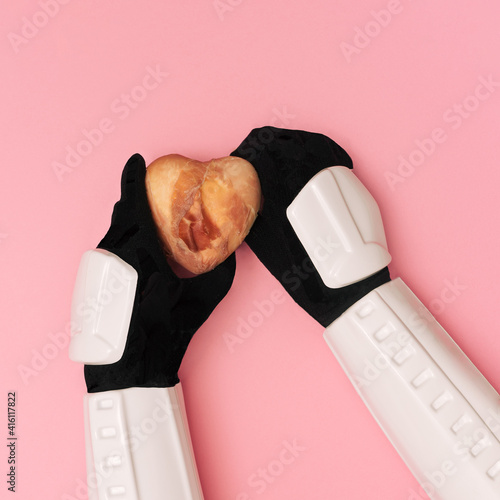 Storm trooper hands are offering heart covered in raw meat on pink background. photo