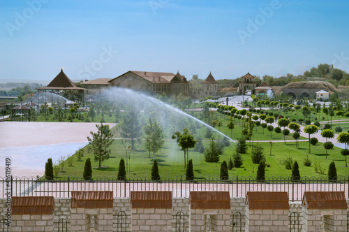 Watering the lawn in the historic park of the old fortress.