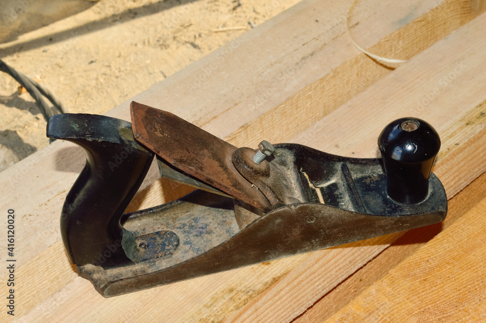 close up - old work planer on the background of planed wooden boards close up - old work planer on the background of planed wooden boards
