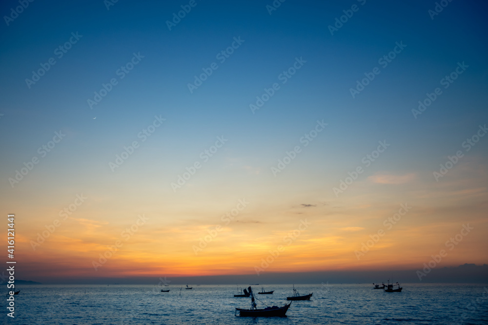 silhouette of fishing boats against sunset