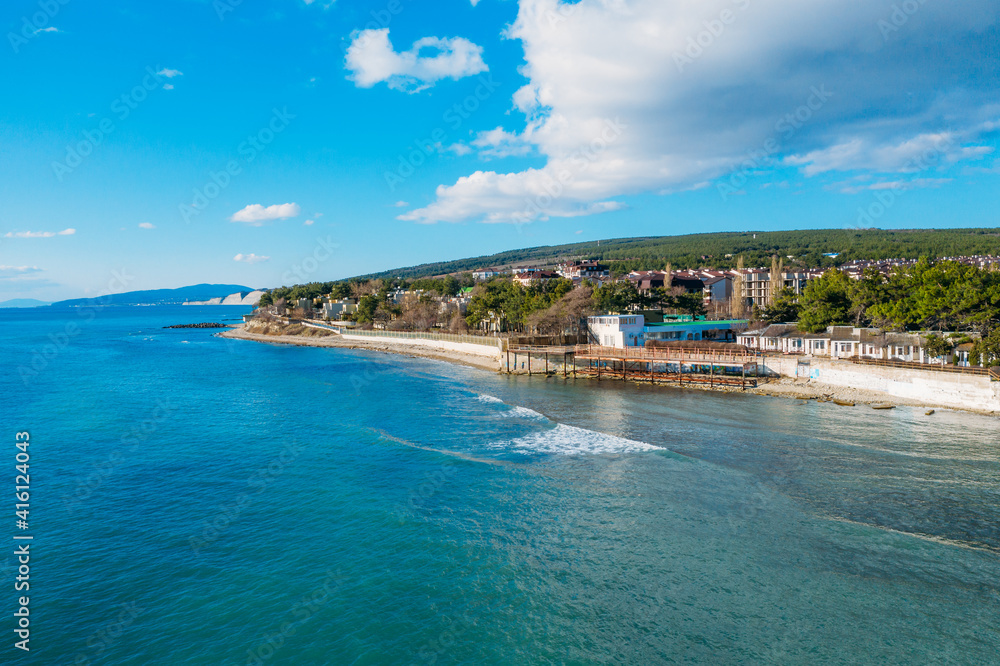 Aerial view of Divnomorskoe small sea resort town on Black Sea coast, beautiful seascape in sunny day.