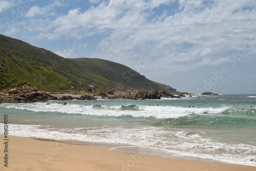 Waves on the beach and mountains in the background. Robberg Nature Reserve, Plettenberg Bay, South Africa.