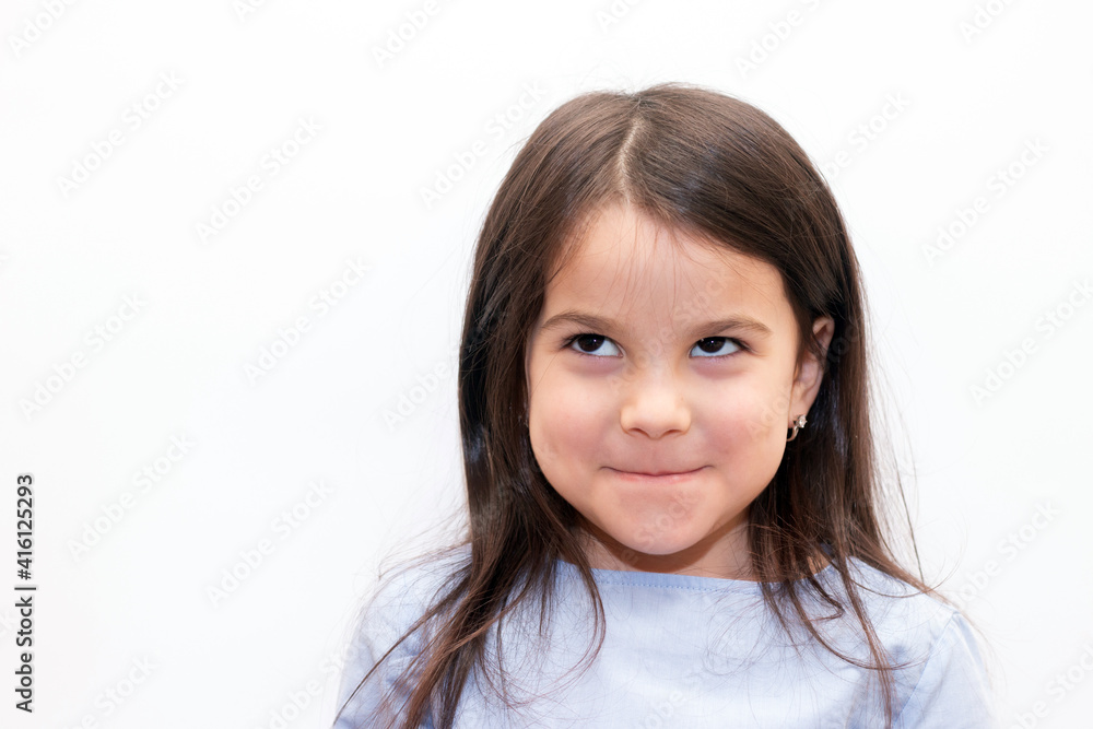 Little girl with dark hair and brown eyes smiles shyly on white background Little girl with dark hair and brown eyes smiles shyly on white background