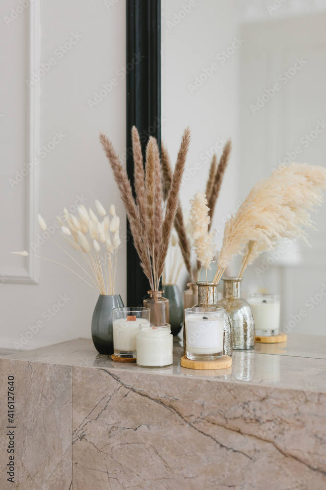 Plakat Candles, dried flowers on the marble fireplace. The concept of comfort and relaxation.