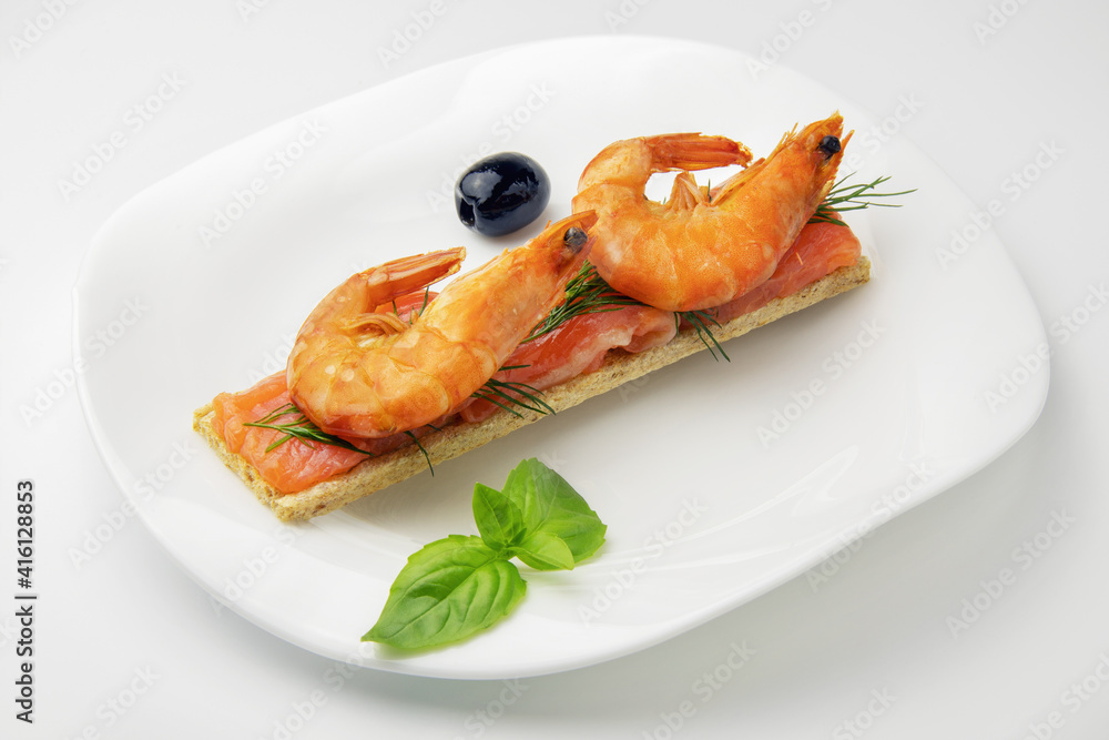 diet bread with slices of red fish and shrimp with sprig of dill, olives in the white plate on white background, healthy food