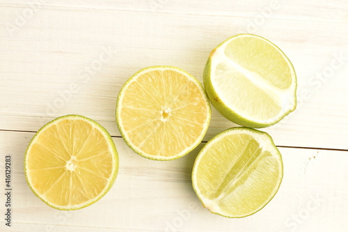 Four halves of juicy lime, close-up, on a painted wooden table.