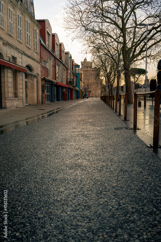 empty street at evening in La rochelle, France. Saint Nicolas Tower in the background © mathilde