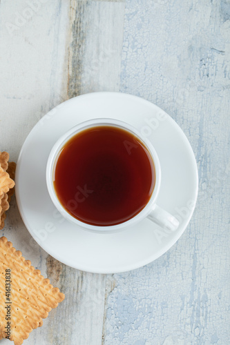 Aroma cup of tea with tasty crackers on a wooden table