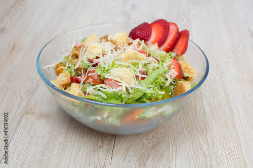 Chicken salad, strawberries, Parmesan cheese, lettuce and tomato in glass container