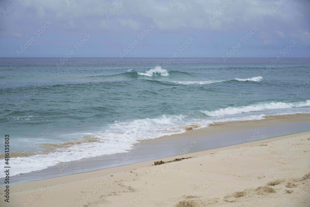 Sea with small waves at Praia da Reserva, on a partially cloudy day. Located in Rio de Janeiro