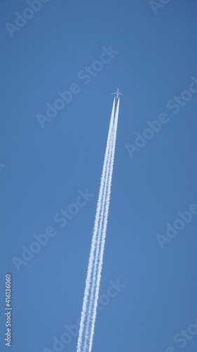 dynamic jetplane in the sky with trail against luminous blue sky