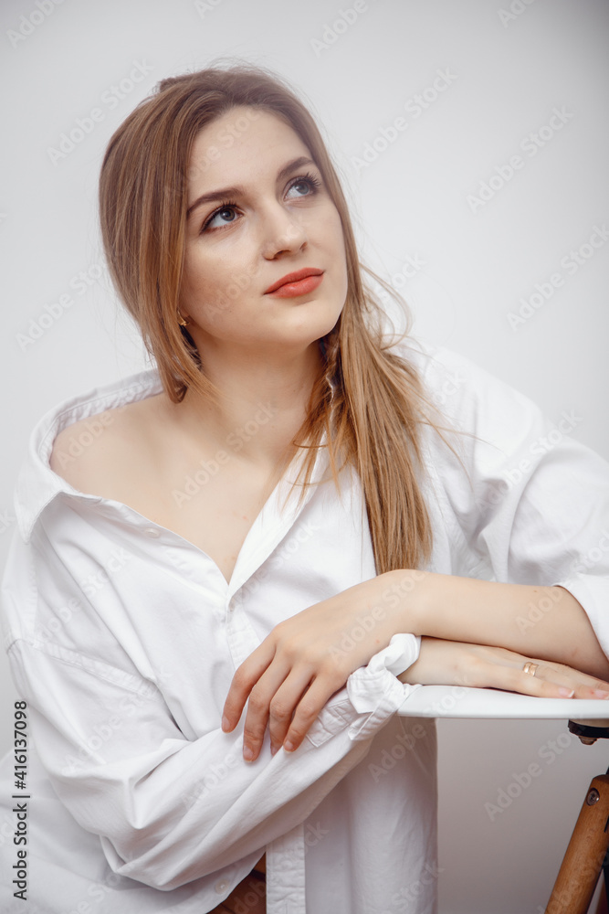 Businesswoman confident portrait. Fashion shoot of young sexy in white studio street style. Fashion photo. Caucasian female with long hair. Close-up portrait of a beautiful girl of the European race. Businesswoman confident portrait. Fashion shoot of young sexy in white studio street style. Fashion photo. Caucasian female with long hair. Close-up portrait of a beautiful girl of the European race.