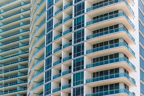 Abstract view on residential apartment condo condominium complex building with windows balconies painted in white blue on sunny day © Kristina Blokhin