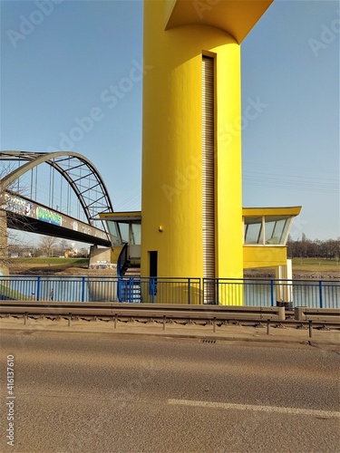 A yellow raisable bridge in the harbour photo