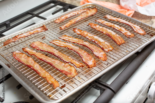A closeup view of a tray of baked bacon strips.