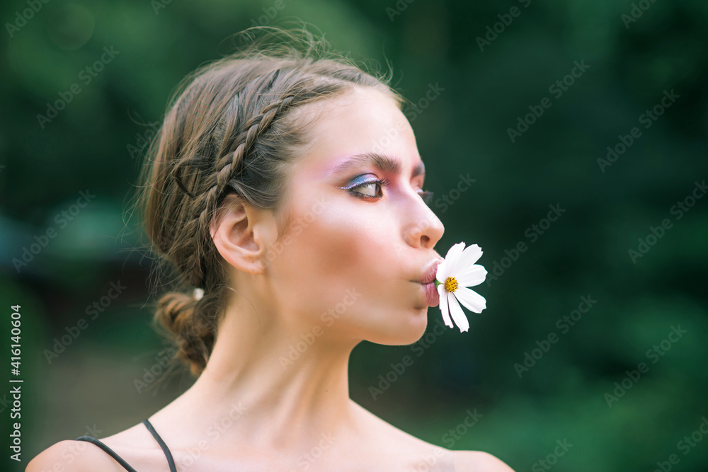 Spring woman with daisy flower in mouth. Beauty, nature concept. Fashion look, makeup. Youth, flowering, blossom, bloom. Spring woman with daisy flower in mouth. Beauty, nature concept. Fashion look, makeup. Youth, flowering, blossom, bloom.