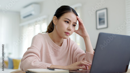 Fényképezés Back rear view young asian woman employee work from home using computer notebook videocall meeting conference angry annoy with low poor unreliable internet wifi connection problem issue outage