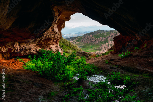 beautiful cave in the andes of peru with a look to the tinajani canyon with a beautiful blue sky and clouds.