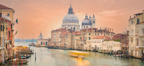 Stunning view of the Venice skyline with the Grand Canal and Basilica Santa Maria Della Salute in the distance during a dramatic sunrise. Picture taken from Ponte Dell’ Accademia. © Travel Wild