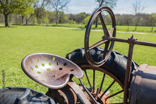 Old rusty tractor seat, wheel, and steering wheel