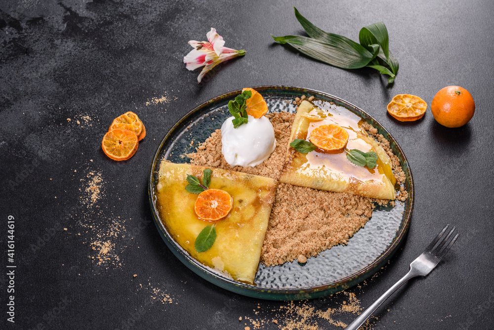 Delicious fresh pancakes on a plate with sweet sauce and ice cream decorated with mint Delicious fresh pancakes on a plate with sweet sauce and ice cream decorated with mint