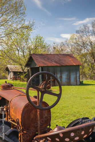 Old rusty tractor with barn in background