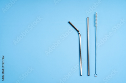 The modern trend towards caring for the environment. Kit of reusable metal beverage straws of various diameters with cleaning tool