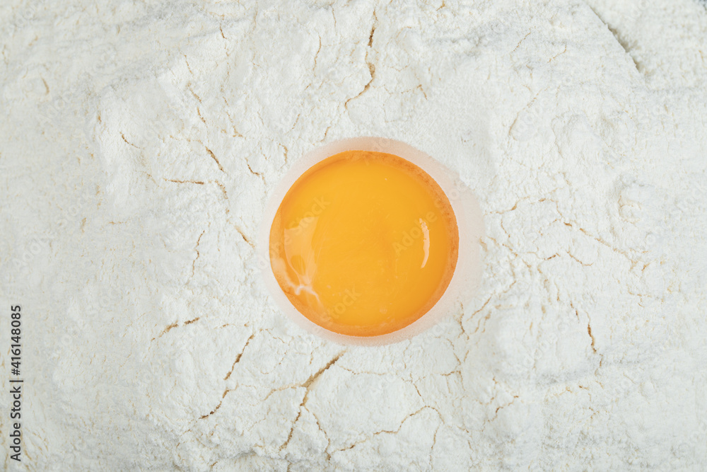 Flour with raw yolk on a gray background Flour with raw yolk on a gray background