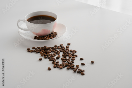 Cup of coffee and roasted coffee beans on the table