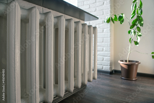 Cast iron heating radiator hanging in a room, close up, selective focus