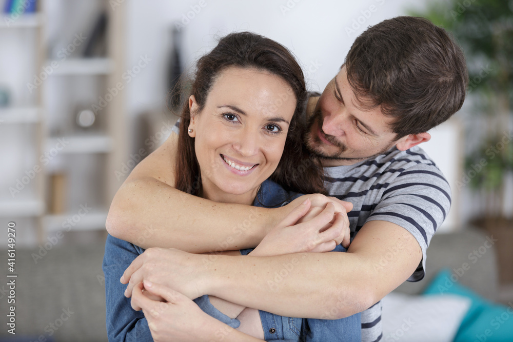 Fototapeta premium affectionate couple embracing woman looking at camera