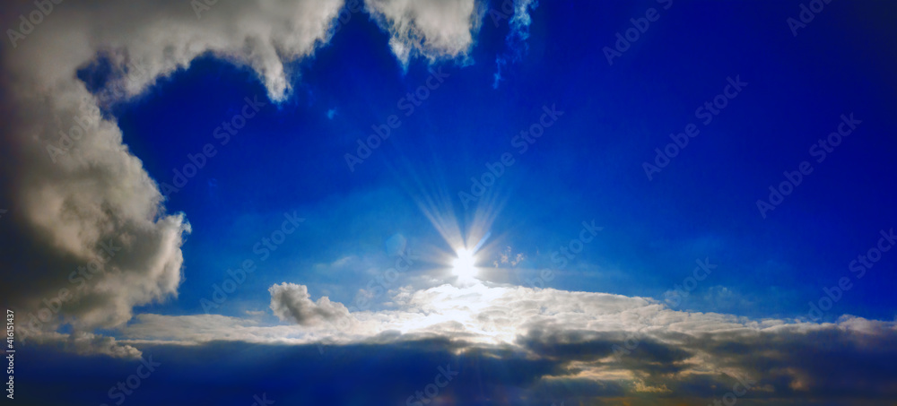 Beautiful view of Sun shining above clouds at deep blue sky