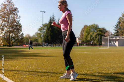 Girl exercising with a rubber band in the stadium