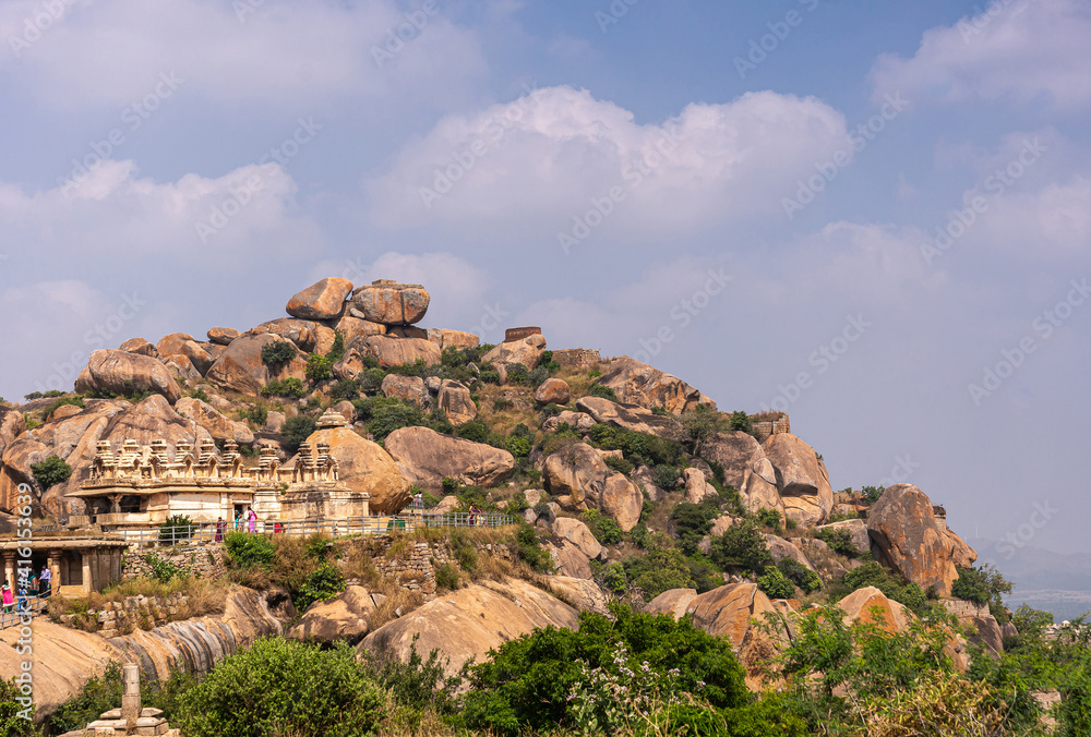 Chitradurga, Karnataka, India - November 10, 2013: Fort or Elusuttina Kote. Brown boulders stacked above Hidambeswara Temple ruinous buildings under blue cloudscape. Clothes add colors