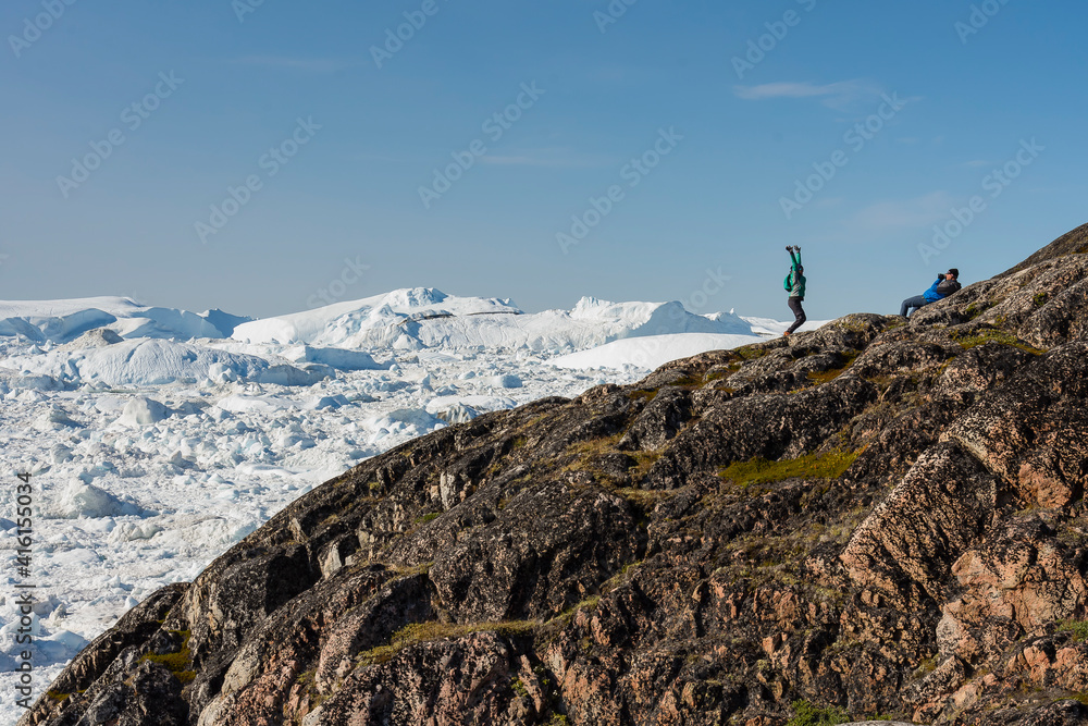 Greenland. Ilulissat. Visitors taking in the expanse of the Icefjord.