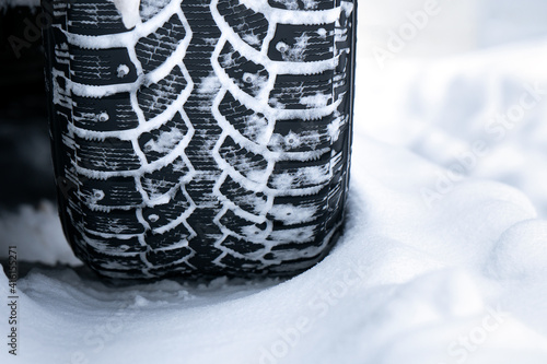 Winter studded tire tread standing in the snow close up